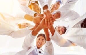 Medical students stack hands together