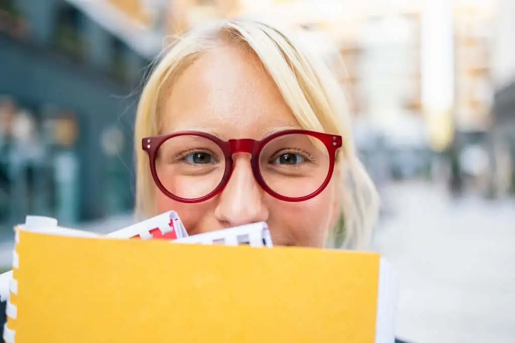 Blonde schoolgirl with books in front of her